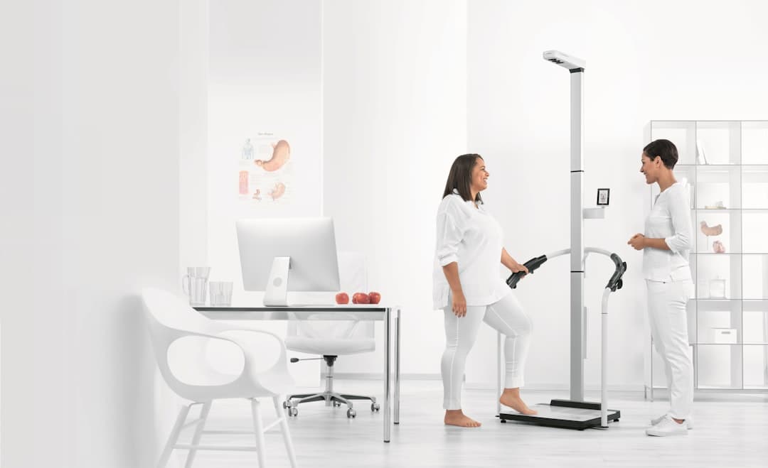 A clinical team member guides a patient through a body composition analysis using advanced metabolic diagnostic equipment at Atlas Injury to Health's wellness center.
