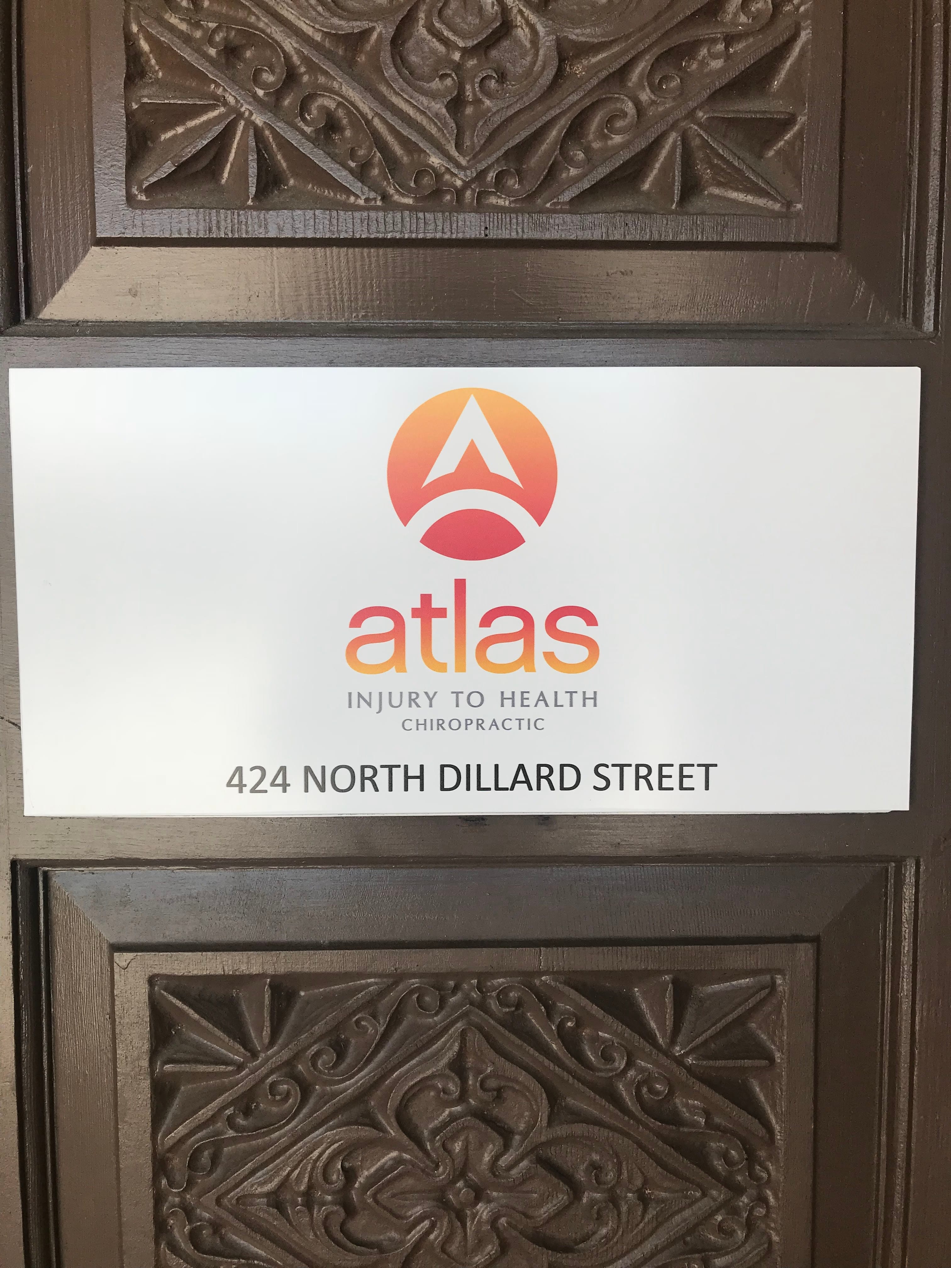 Atlas Injury to Health Chiropractic entrance sign at 424 North Dillard Street, mounted on a carved wooden door