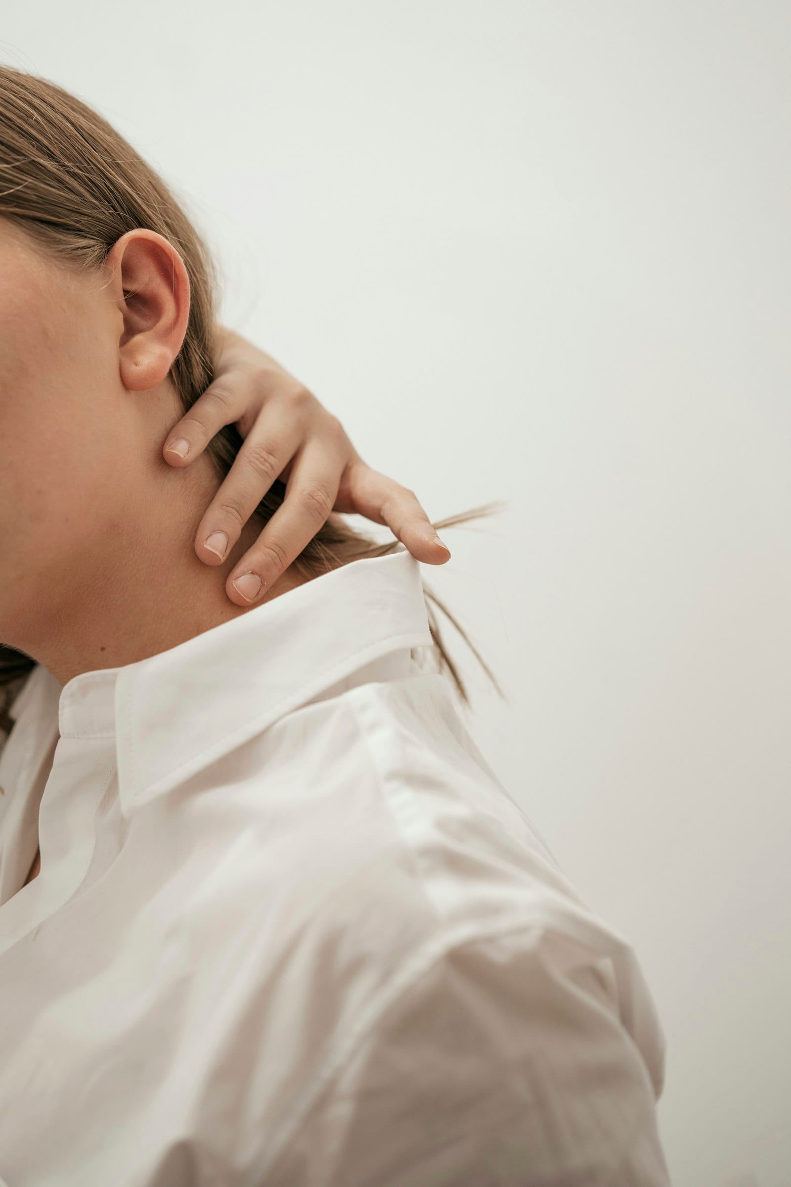 Close-up of a person touching their neck and ear