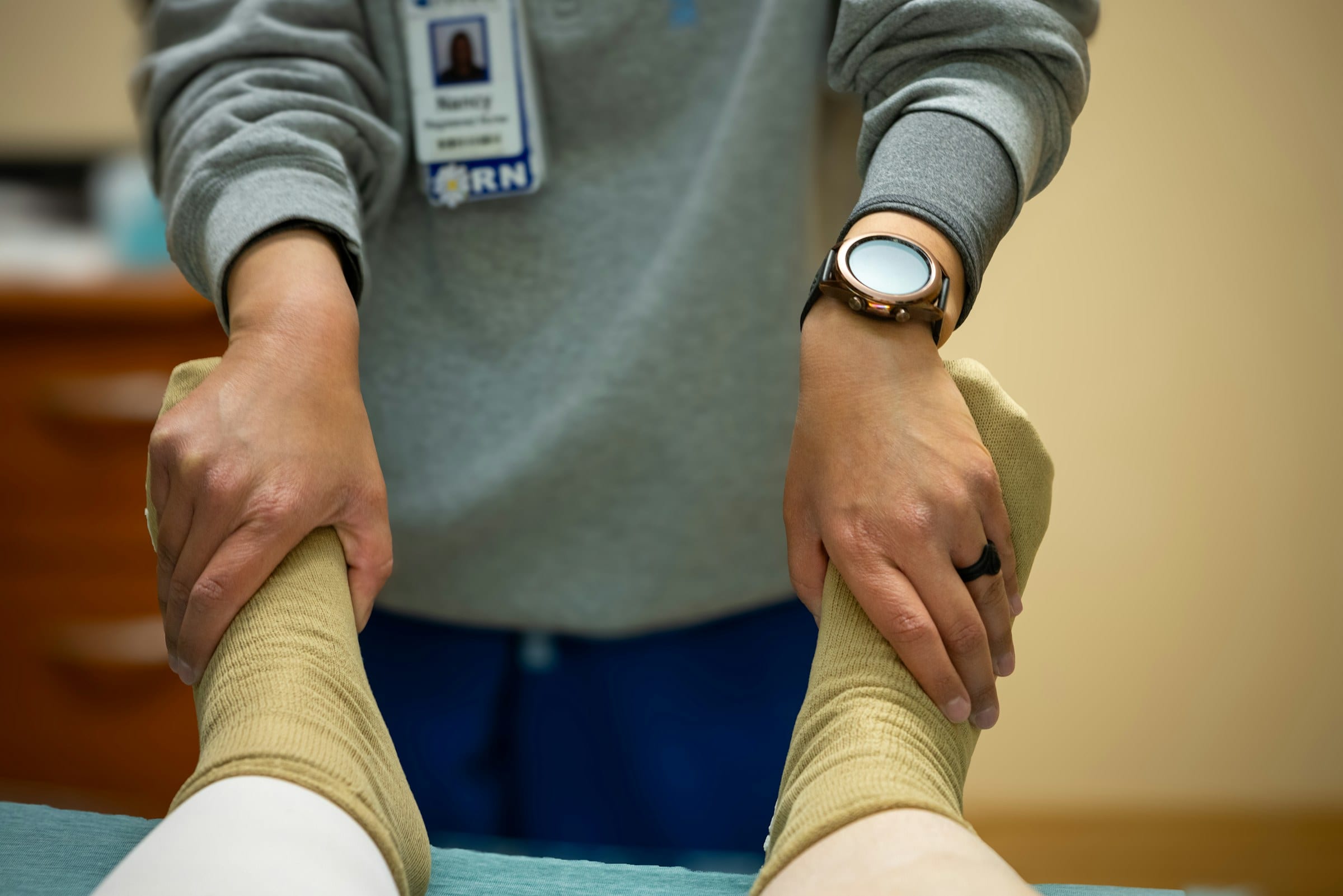 A member of our clinical team gently checks circulation and pulse in a patient's feet during a careful assessment.